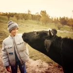 enfant caressant une vache